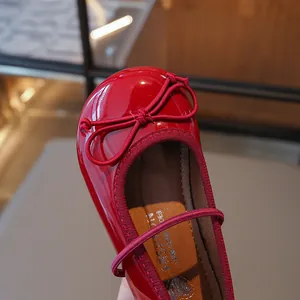 Red patent leather girls' flat shoes featuring a bow detail and heart pattern insole