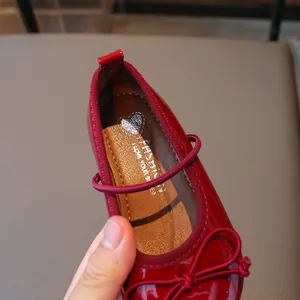 Charming red patent leather girls' Mary Jane shoes featuring a stylish bow design