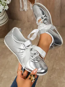 Trendy silver metallic GAT sneakers with elegant white ribbon laces for a chic look.