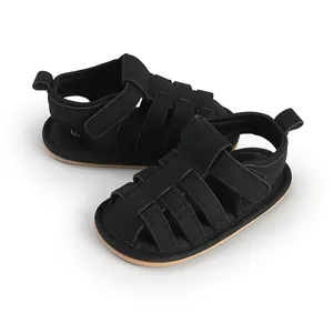 Gedetailleerd beeld van zwarte baby sandalen met zachte zool en klittenbandsluiting.