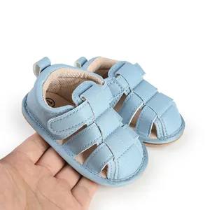 Macro view of blue baby summer sandals held in hand showing soft material