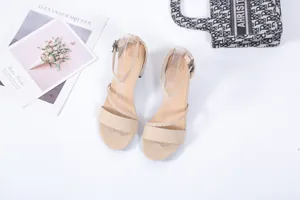 Détail de sandales à talons blocs en daim beige avec bride tressée et boucle à la cheville
