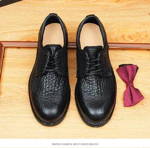 Vue de dessus de chaussures Derby en cuir de buffle noir texturé sur un fond bois