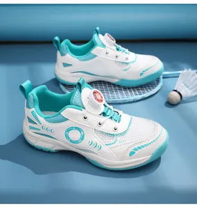 Detalle de zapatillas de bádminton infantiles con cierre rotativo en blanco y turquesa.