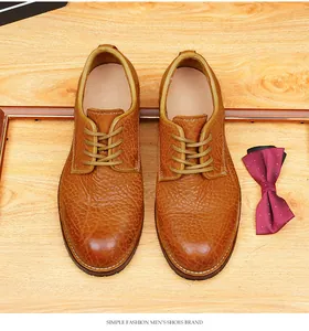 Vue de dessus de chaussures Derby en cuir marron texturé avec nœud papillon sur bois