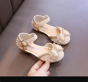 Detailansicht der cremefarbenen Mädchen-Prinzessin-Schuhe mit Perlen und Schleife
