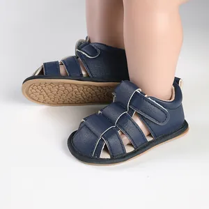 Close-up of navy blue breathable baby sandals with non-slip tan soles for toddlers