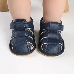 Front close-up view of dark blue soft-sole baby sandals designed for infant walking support