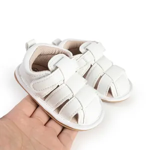 Handheld detail view of white breathable summer baby sandals for newborn pre-walkers.