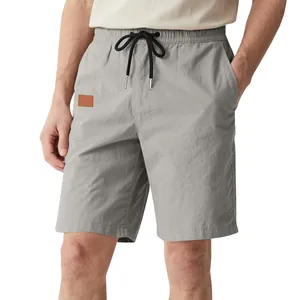Détail d'un short décontracté gris pour homme avec cordon de serrage et écusson.