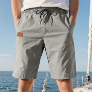 Vue détaillée du short de plage décontracté gris pour homme sur un voilier en mer