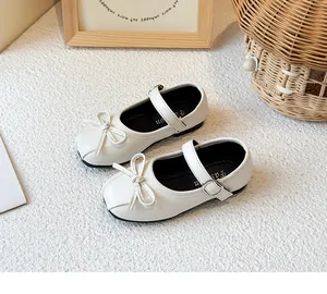 Detailansicht der weißen Mädchen-Mary-Janes mit süßer Schleife und verstellbarem Riemen.