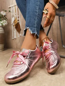 Close-up of metallic pink retro German Army Trainer sneakers with silk ribbons
