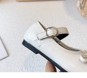Detailaufnahme eines weißen Mary-Jane-Schuhs für Mädchen mit Schleife und Schnallenriemen
