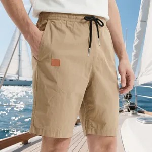 Vue détaillée d'un short d'été kaki pour homme avec cordon sur un pont de yacht ensoleillé
