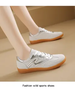 Detalle de zapatillas blancas estilo GAT con detalles plateados en un modelo real