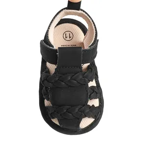 Close-up detail of black braided baby sandals featuring breathable fabric and size label