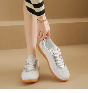 Primer plano de zapatillas blancas y plateadas estilo German Army con suela de goma para mujer