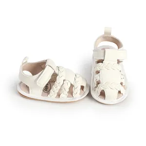 Detail of white braided baby sandals with soft sole and velcro strap.