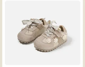 Detailed view of beige baby walking shoes featuring floral accents and elegant satin bows