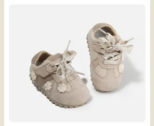 Detailed view of beige baby walking shoes with floral accents and satin bows