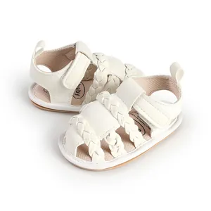 Close-up detail of white braided straps on baby sandals with comfortable soft soles.
