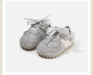 Detailed view of grey baby girl toddler shoes featuring satin bows and floral 3D appliqués