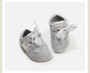 Close-up of grey toddler girl walking shoes with soft sole and ribbon bow detail