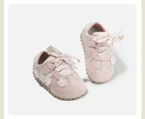 Detailed view of pink baby girl walking shoes with floral accents and soft soles.