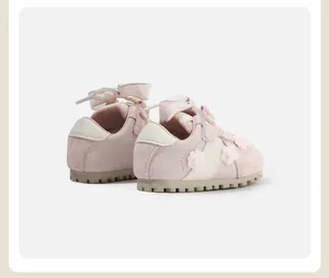 Rear detail of pink toddler shoes featuring satin ribbon bows and 3D floral accents