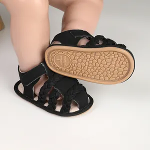 Close-up of black braided baby sandals with non-slip patterned rubber sole