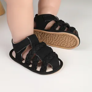 Close-up of black braided baby sandals with breathable design for infants 0-12 months.
