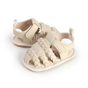 Detail view of beige baby sandals with braided straps and soft breathable sole.
