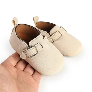 Detailed close-up of beige matte suede baby shoes featuring an adjustable metal buckle strap