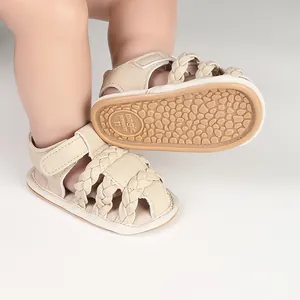 Detailed macro view of cream braided baby sandals featuring an anti-slip textured rubber sole