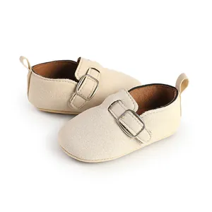 Detailed macro view of beige matte suede baby shoes featuring a vintage metal buckle strap