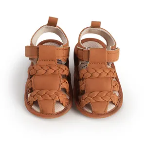 Close-up view of brown baby sandals with woven leather straps and Velcro