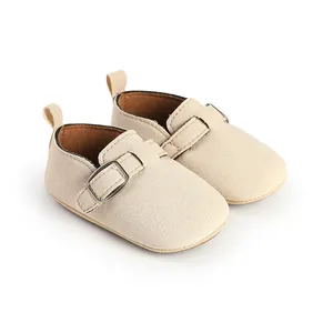 High-quality detail shot of soft beige suede baby loafers featuring a stylish metal buckle