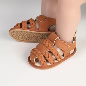 Close-up of brown braided straps and soft sole on infant summer walking sandals