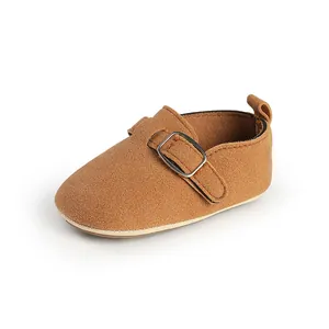 Detailed side view of a brown suede vintage style baby flat shoe with buckle strap
