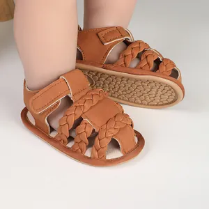 Close-up detail of brown braided baby sandals featuring non-slip soles and Velcro straps