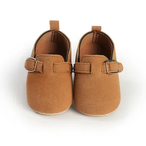 Macro close-up view of retro brown buckled baby shoes with a soft faux suede texture