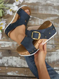 Detailopname van marineblauwe sleehak sandalen met verstelbare gesp en kurkzool