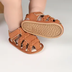 Close-up of tan braided baby sandals with non-slip rubber sole detail.