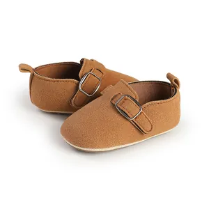 Close-up of brown suede baby shoes with buckle strap and comfortable flat sole