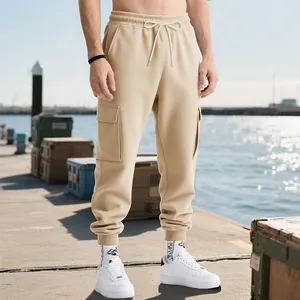 Close-up detail of khaki men's heavyweight cargo joggers in outdoor pier setting.