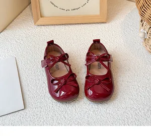 Top view of red patent leather girl's Mary Jane shoes featuring two cute bows and soft soles