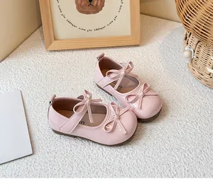 Detailed view of pink patent leather girls' Mary Jane shoes with double bow accents.