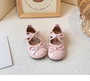 Detail view of stylish pink patent leather princess shoes with double bows