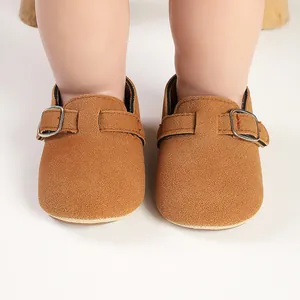 Close-up front view of brown frosted suede baby shoes featuring adjustable buckle straps